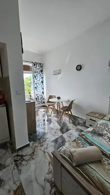 a bedroom with a marble floor and a table and chairs at Tinina Basta in Sutomore