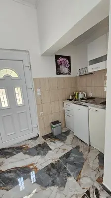 a kitchen with a white door and a counter at Tinina Basta in Sutomore