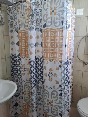 a bathroom with a shower curtain and a sink at Tinina Basta in Sutomore