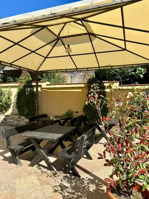 a picnic table under an umbrella in a garden at Casablanca in Sutomore