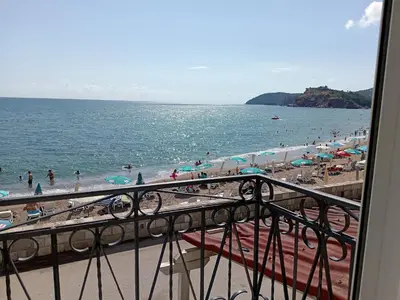 a view of a beach with people and umbrellas at Apartmani Lakovic in Sutomore