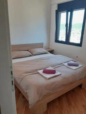 a bedroom with a large bed with two towels on it at Dubrava Czarnogóra in Dobra Voda