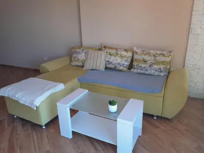 a living room with a yellow couch and a table at Dubrava Czarnogóra in Dobra Voda