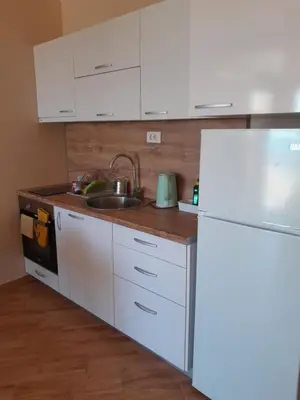 a white kitchen with a sink and a refrigerator at Dubrava Czarnogóra in Dobra Voda
