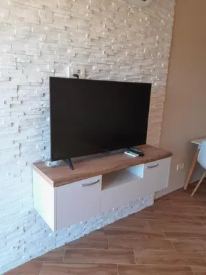 a flat screen tv on top of a white entertainment center at Dubrava Czarnogóra in Dobra Voda