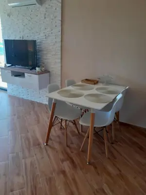 a table and chairs in a living room with a television at Dubrava Czarnogóra in Dobra Voda
