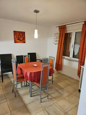 a dining room with a red table and chairs at Villa Amela Dubrava in Bar