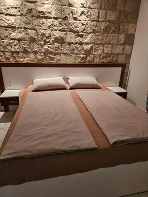 a large bed in a bedroom with a stone wall at Villa Amela Dubrava in Bar