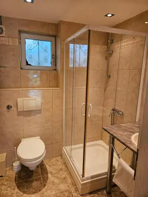 a bathroom with a shower and a toilet and a sink at Villa Amela Dubrava in Bar