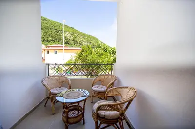 a balcony with chairs and a table and a window at Newly refurnished apartment with large garden in Budva