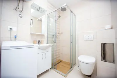 a bathroom with a shower and a toilet and a sink at Newly refurnished apartment with large garden in Budva