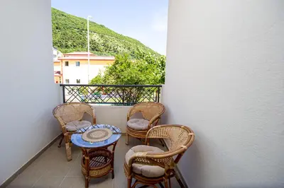 a balcony with chairs and a table on a balcony at Newly refurnished apartment with large garden in Budva