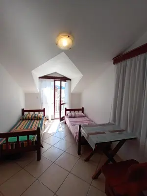 a room with two beds and a table in it at Beli angel in Rafailovici