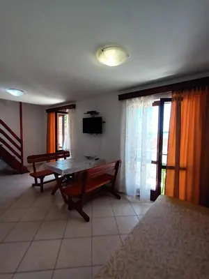 a living room with a wooden table and a television at Beli angel in Rafailovici
