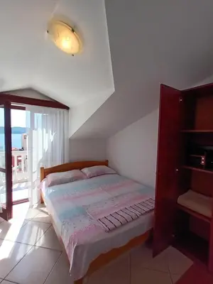 a bedroom with a bed and a large window at Beli angel in Rafailovici