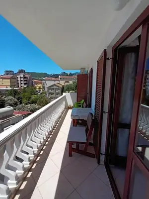 a balcony with two tables and a view of a city at Beli angel in Rafailovici