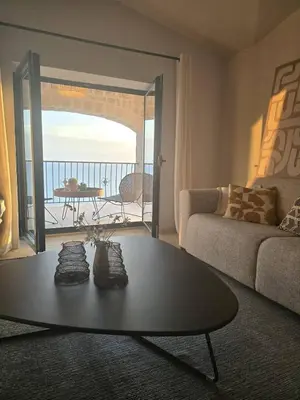 a living room with a table and a view of the ocean at Villa Drobni Pijesak in Budva