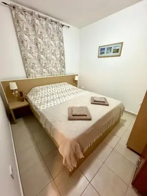 a bedroom with a bed with two towels on it at Sun Bay Petrovac in Petrovac na Moru