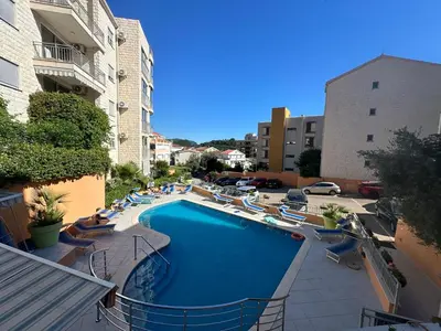 a swimming pool with lounge chairs and a hotel at Sun Bay Petrovac in Petrovac na Moru