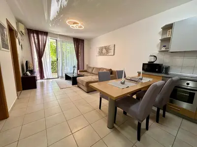 a living room with a table and a couch at Sun Bay Petrovac in Petrovac na Moru