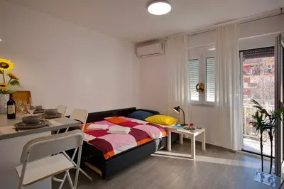 a bedroom with a bed and a table and a dining room at Lola - New, best located, elegant & super tidy in Kotor