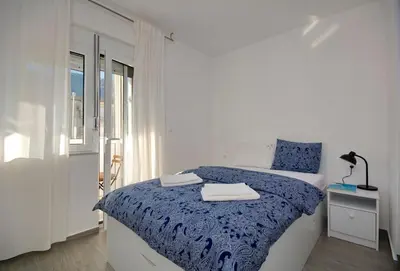 a white bedroom with a bed with a blue blanket at Lola - New, best located, elegant & super tidy in Kotor