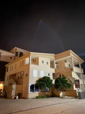 a large apartment building at night with a dark sky at Apartmani Adelina in Donji Štoj
