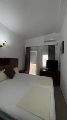 a hotel room with two beds and a television at Apartmani Adelina in Donji Štoj