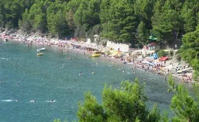 a group of people swimming in the water at a beach at Apartment Rumi Sutomore in Sutomore