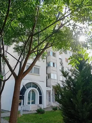 a white building with a tree in front of it at Apartment Rumi Sutomore in Sutomore