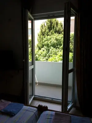 a bedroom with a door open to a balcony at Mirko Apartments Budva in Budva