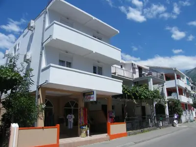 a white building on the side of a street at Mirko Apartments Budva in Budva