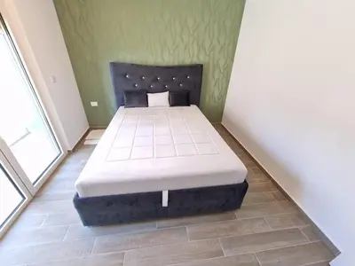 a bedroom with a bed in the corner of a room at MilLaz Apartman in Becici