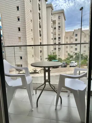 a table and chairs on a balcony with a view of a street at MilLaz Apartman in Becici