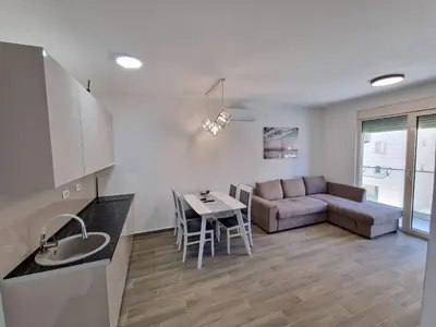 a kitchen and living room with a couch and a table at MilLaz Apartman in Becici