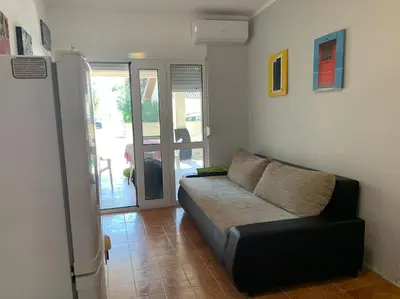 a living room with a couch and a sliding glass door at Kite paradise - Ground floor for 5, Velika plaza- Long Beach in Ulcinj