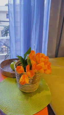 a vase with orange flowers sitting on a table at Centre Budva Green in Budva