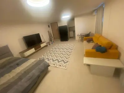 a bedroom with a bed and a couch and a tv at Podgorica 23 in Podgorica