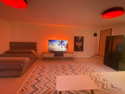 a bedroom with a bed and a table and red lights at Podgorica 23 in Podgorica