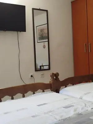 a bedroom with two beds with a mirror and a television at APARTMAN Biser in Kotor