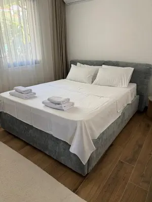 a large bed with white sheets and towels on it at Royal Oasis Seaview - Sveti Stefan in Sveti Stefan