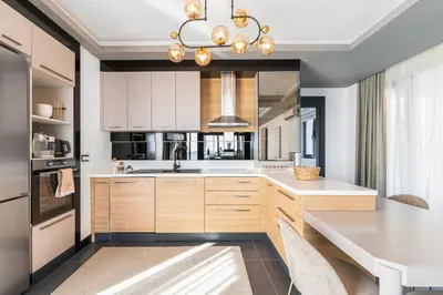 a kitchen with white cabinets and a chandelier at Royal Oasis Seaview - Sveti Stefan in Sveti Stefan