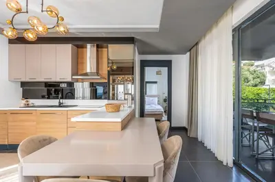 a kitchen and dining room with a white table and chairs at Royal Oasis Seaview - Sveti Stefan in Sveti Stefan