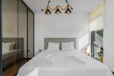a bedroom with a white bed with two white towels at Royal Oasis Seaview - Sveti Stefan in Sveti Stefan