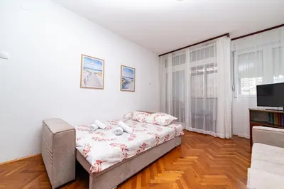 a bedroom with a bed and a tv in it at Apartment Simanic in Budva