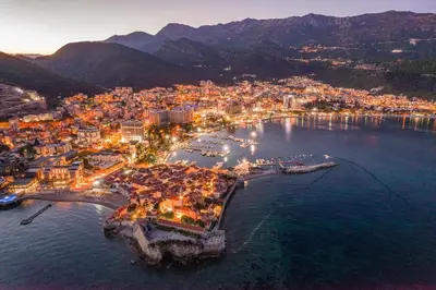 an aerial view of a city with a harbor at night at Apartment Simanic in Budva