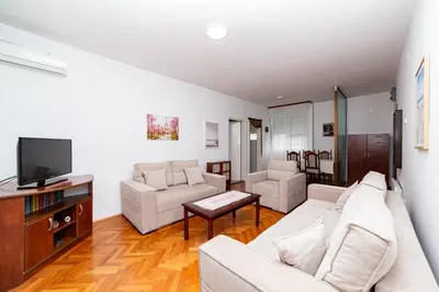 a living room with a couch and a tv at Apartment Simanic in Budva