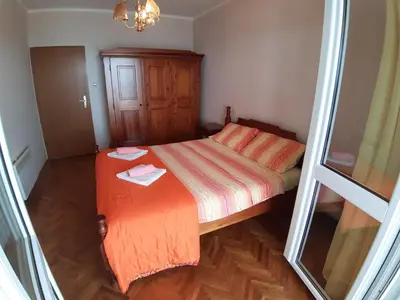 a small bedroom with a bed with an orange blanket at Vesna Apartments in Ulcinj