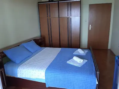 a bedroom with a blue bed with two towels on it at Vesna Apartments in Ulcinj