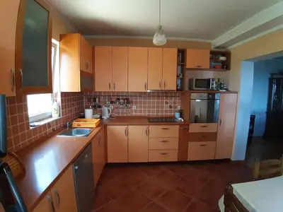 a kitchen with wooden cabinets and a sink in it at Vesna Apartments in Ulcinj